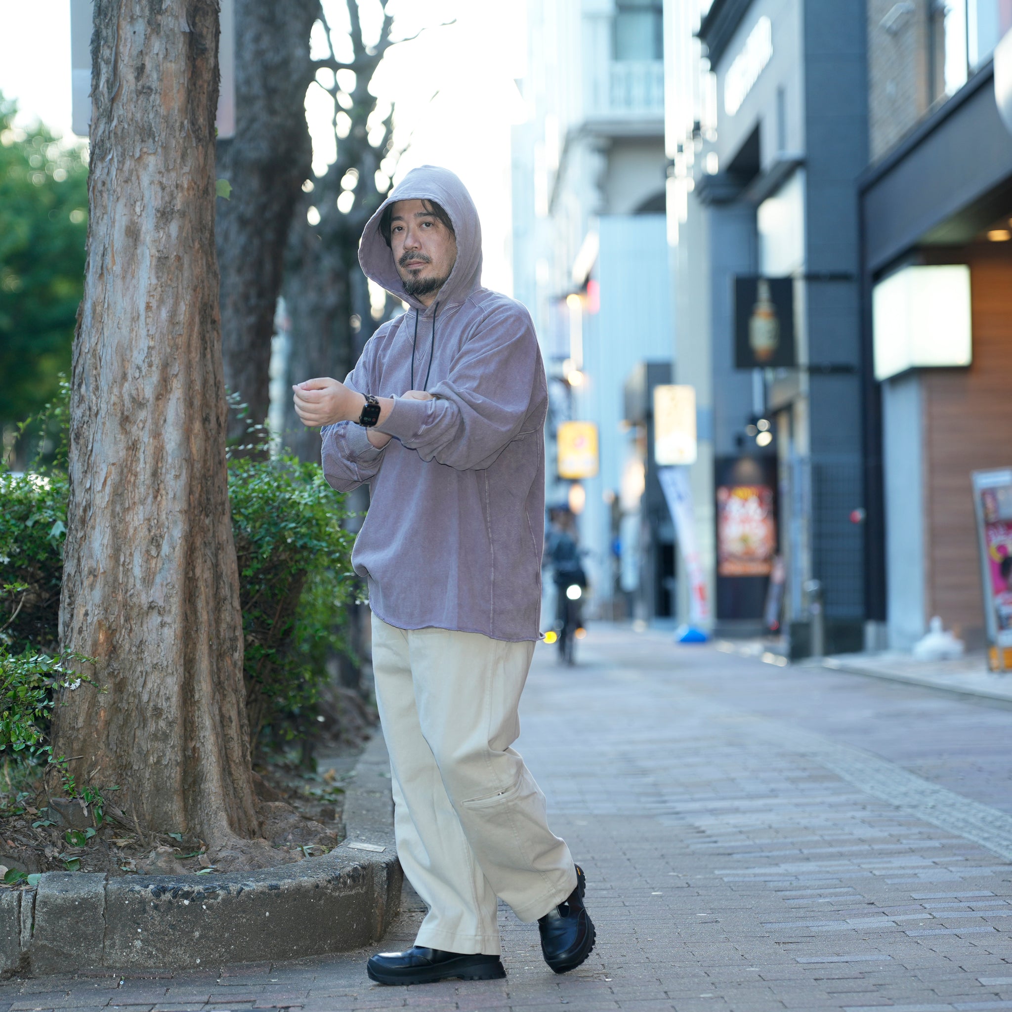 空紡糸で仕立てたTシャツ素材の軽量フーディー。ビンテージ感ある黒の褪せ感と立体フードが特徴。
